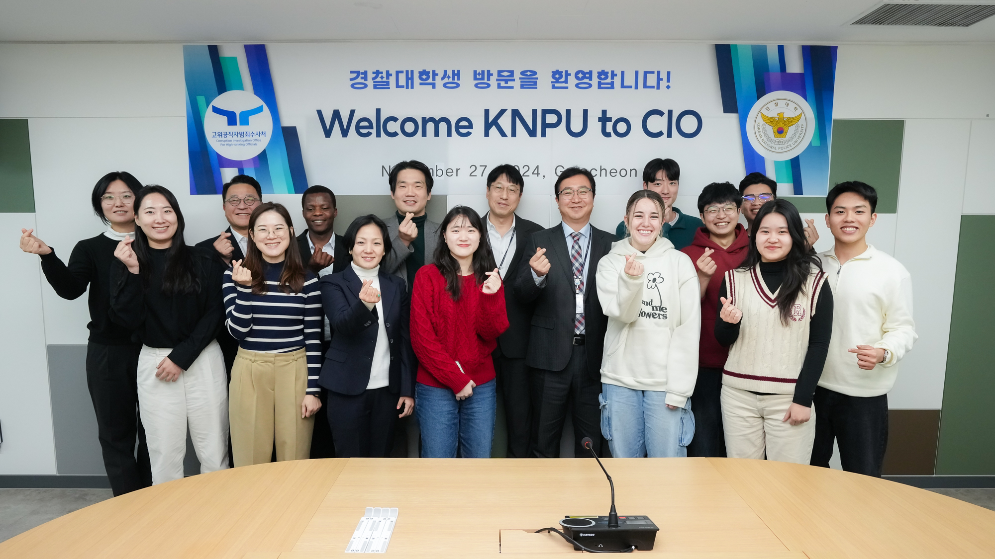 경찰대학생 방문을 환영합니다! Welcome KNPU to CIO 천막 아래에서 손하트를 하고 있는 해외유학생 10명의 모습